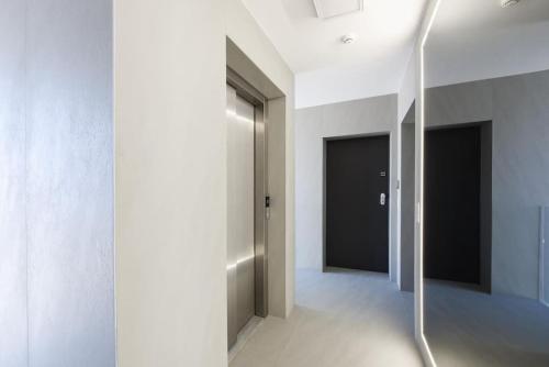 a hallway with white walls and a glass door at FUX Penthouse Whirlpool Meerblick Zadar in Zadar