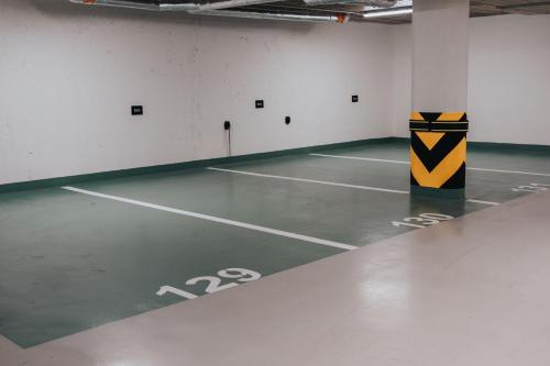 an empty parking lot with a yellow and black pole at MOLO LIPNO RESIDENCE in Lipno nad Vltavou