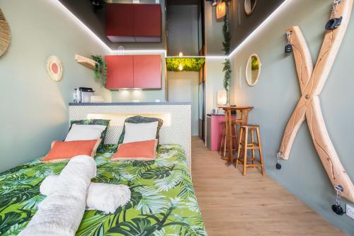 - une chambre dotée d'un lit avec des feuilles vertes dans l'établissement Jungle House héliopolis, au Cap d'Agde