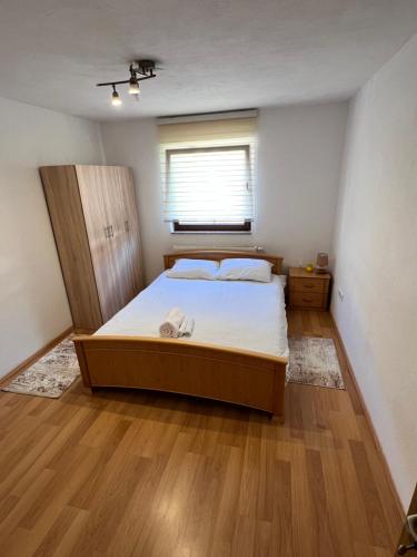 a bedroom with a large bed and a window at SA Apartment in Sarajevo
