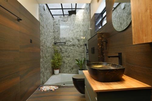 a bathroom with a bowl sink and a shower at Mickey Homestay in Thekkady