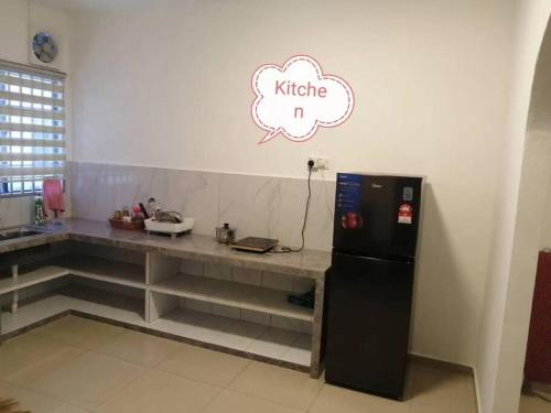 eine Küche mit einer Theke und einem Kühlschrank im Zimmer in der Unterkunft Simpang Ampat QQ in Simpang Ampat