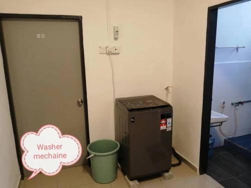 ein Badezimmer mit einer Kühlschrankmaschine und einem Mülleimer in der Unterkunft Simpang Ampat QQ in Simpang Ampat