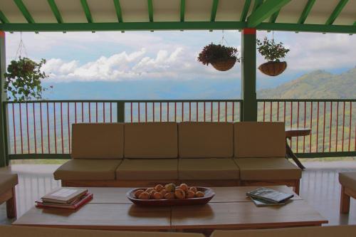 a living room with a couch and a bowl of fruit on a table at Finca Hotel Isla del Encanto in Támesis