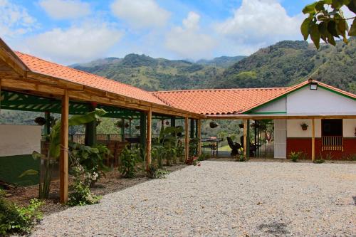a house with a roof with mountains in the background at Finca Hotel Isla del Encanto in Támesis