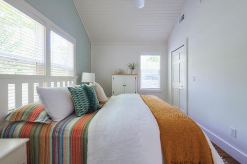 a white bedroom with a bed with a colorful blanket at Lucky Penny - Lake Access right around the corner - Newly remodeled home in Glenn