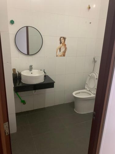a bathroom with a sink and a toilet and a mirror at Khách sạn lê lợi in Quang Ngai