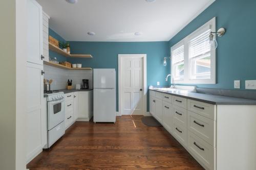 a kitchen with white cabinets and blue walls at Lucky Penny - Lake Access right around the corner - Newly remodeled home in Glenn