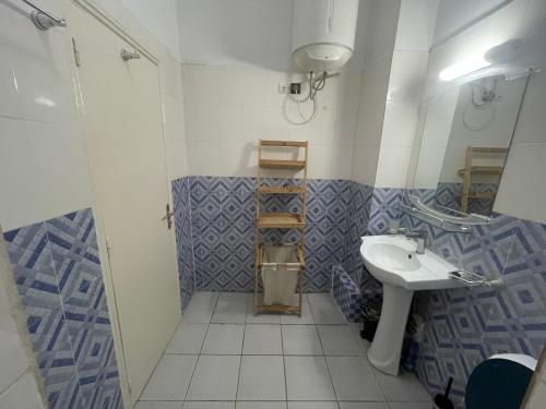 La salle de bains est pourvue d'un lavabo et d'une douche. dans l'établissement Tarablue appart, En plein centre-ville, Agréable & spacieux, à Libreville