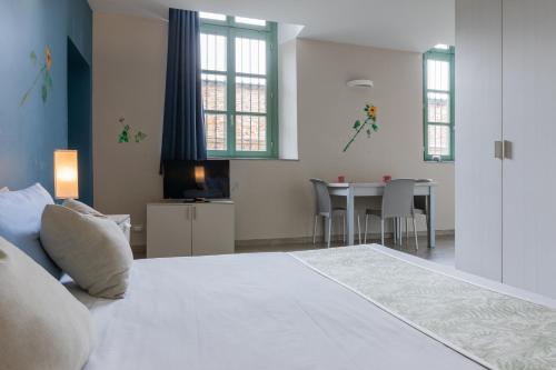 1 dormitorio con 1 cama y 1 mesa con sillas en Housing Giulia en Turín