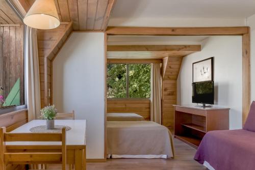 a bedroom with two beds and a tv and a window at Soft Bariloche Hotel in San Carlos de Bariloche