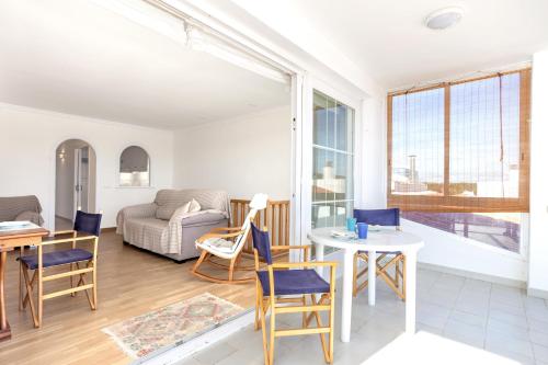 een woonkamer met een tafel en stoelen en een bank bij Preciosas vistas en Es Grau in Es Grau