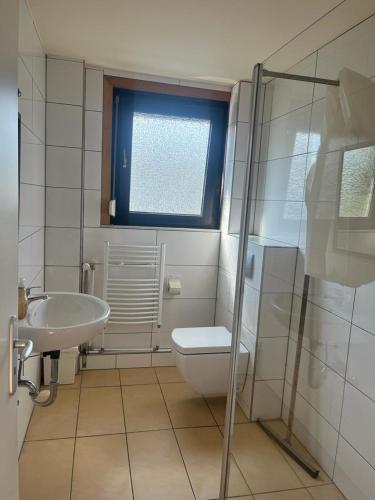 y baño con aseo, lavabo y ducha. en Pension Highway Bielefeld Senner Hellweg, en Bielefeld
