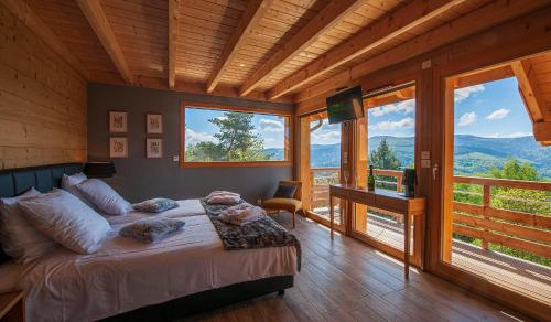 a bedroom with a bed in a room with windows at Les Chalets de La Marcairie in Metzeral
