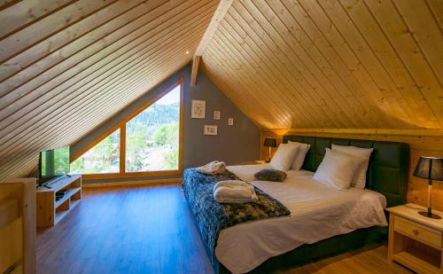 a bedroom with a large bed with a large window at Les Chalets de La Marcairie in Metzeral