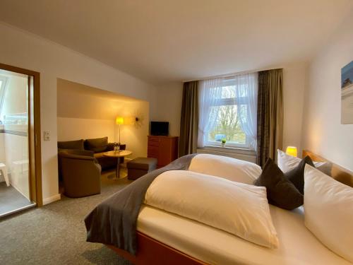 um quarto de hotel com duas camas e uma janela em Kirchspielkrug Landhotel & Restaurant em Westerhever