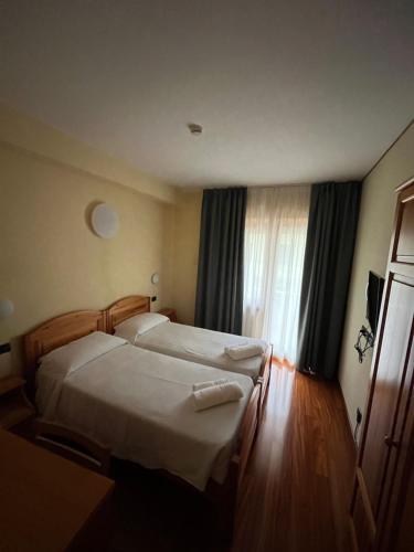 a hotel room with two beds and a window at Hotel Giotto in Garda