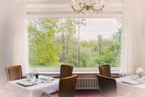 un comedor con 2 mesas y una ventana grande en Haus am Walde, en Bad Fallingbostel