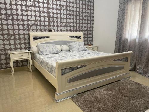 1 cama blanca en un dormitorio con pared en Tarablue appart, En plein centre-ville, Agréable & spacieux, en Libreville