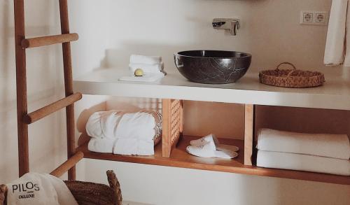 Un estante con toallas y un tazón. en Pilos Suites en Turunc