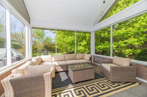 a screened in porch with a couch and chairs at Lily Pond Haven - Private Hot tub - Large recently remodeled home! in Glenn