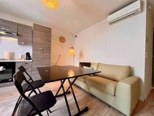 un salon avec une table et un canapé dans l'établissement Appartement 4 prsn Au pied de la Citadelle, à Besançon