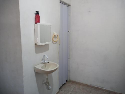 baño con lavabo en una pared blanca en Flat Beira-Mar do CID, en Maragogi