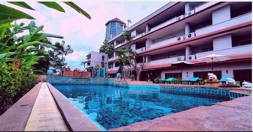 a swimming pool in front of a hotel at Gazebo Resort, Pattaya in Pattaya