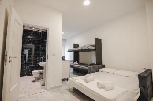 a white room with a bed and a bathroom at Davids Apartments in Sarandë