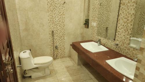 a bathroom with a toilet and a sink at Modern luxury home located in centre of Islamabad in Islamabad