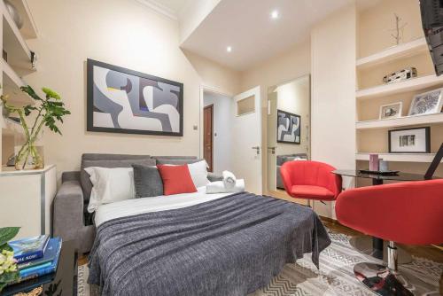 1 dormitorio con 1 cama y 1 silla roja en Ermis exclusive apt in Kolonaki, en Atenas
