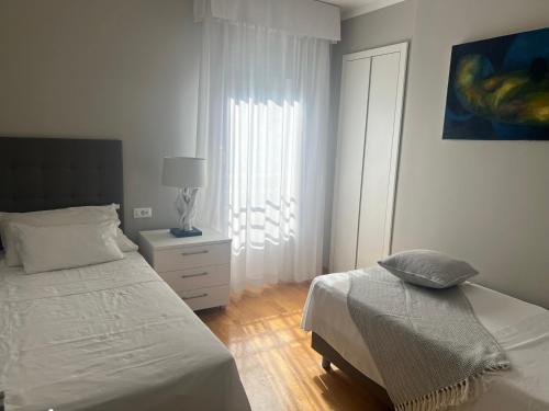 a white bedroom with a bed and a window at Luxe apartment Del Mare in Podstrana