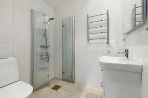 uma casa de banho com um chuveiro, um lavatório e um WC. em Park House Gävle - a modern renovated house in the park - 5A em Gävle