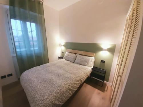 a bedroom with a bed with two pillows and a window at Mami Home Milano Con parcheggio tax1euro in Cormano