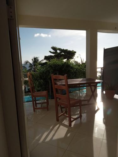 una sala da pranzo con tavolo e 2 sedie di Suite Villa au bord de la mer chez Saloua a Chirongui
