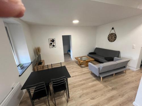 ein Wohnzimmer mit einem Sofa und einem Tisch in der Unterkunft Appartement centre-ville de Lure droit in Lure