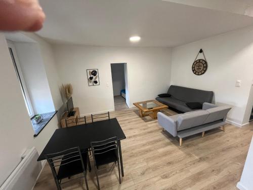 un salon avec un canapé et une table dans l'établissement Appartement centre-ville de Lure droit, à Lure