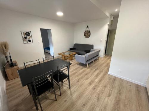 sala de estar con mesa y sofá en Appartement centre-ville de Lure droit en Lure