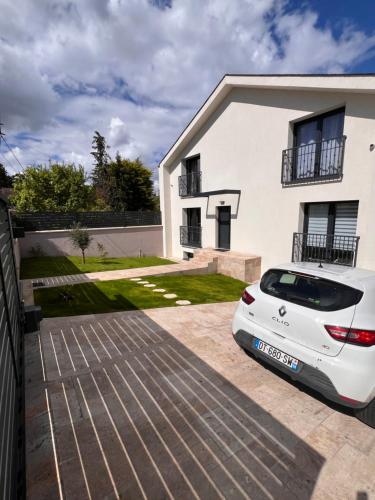 um carro branco estacionado em frente a uma casa em Maison Familiale em Vitry-sur-Seine