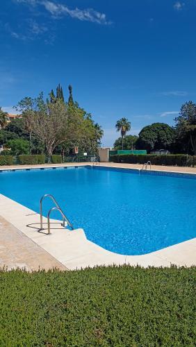 een groot blauw zwembad met een metalen handrail bij Bonito y moderno estudio con vistas al mar in Benalmádena