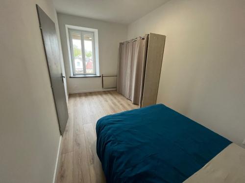 ein leeres Zimmer mit einem Bett und einem Fenster in der Unterkunft Appartement centre-ville de Lure droit in Lure
