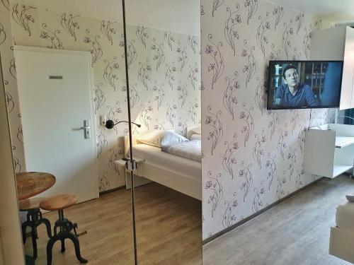 a room with a bed and a tv on the wall at Aparthotel B & L in Bremen