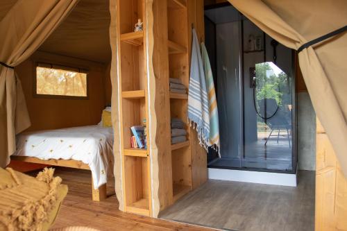 1 dormitorio en una tienda de campaña con cama y ventana en Domus Olea Glamping, en Ceglie Messapica