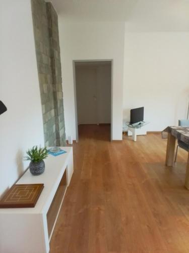 a living room with white walls and a wooden floor at P&P Bergamo Apartment in Bergamo