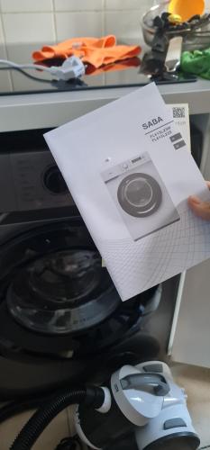 une personne tenant un morceau de papier à côté d'un micro-ondes dans l'établissement appartement pantin, à Pantin