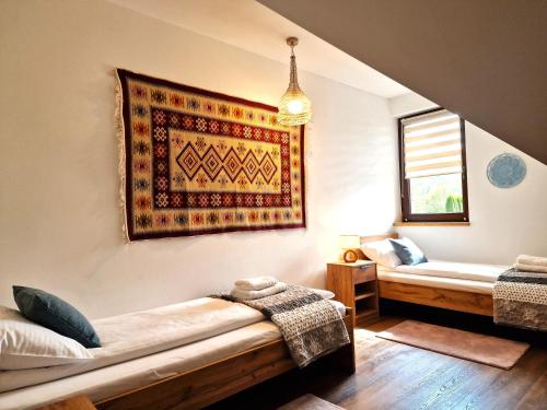 a bedroom with a bed and a rug on the wall at Apartamenty U Pana Jana in Wetlina