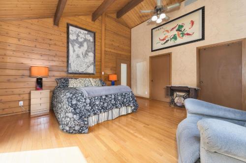 um quarto com uma cama num quarto com paredes de madeira em Hilltop Serenity - entire cabin- scenic oasis 