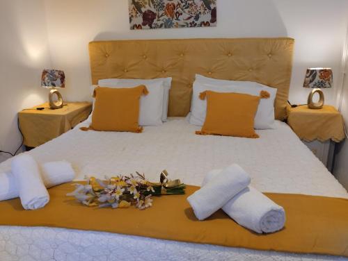 a large bed with towels and flowers on it at Corfu Airport Flat in Corfu Town