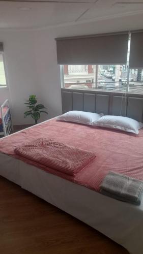 1 dormitorio con 1 cama grande con manta roja en HOTEL JIMENA, en Iquique