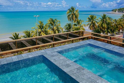 a swimming pool with a view of the beach at Unity #421 - Praia de Cabo branco por Carpediem in Penha